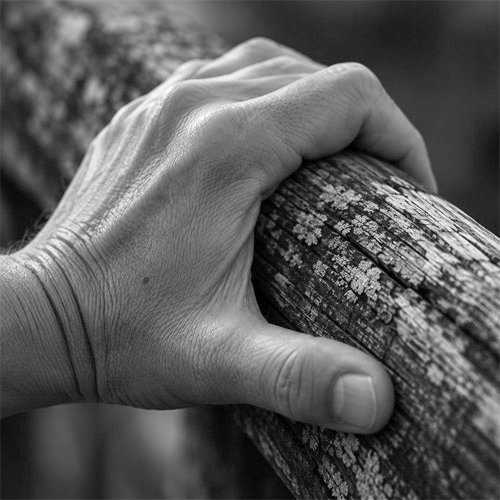 Hand am Holzgeländer
